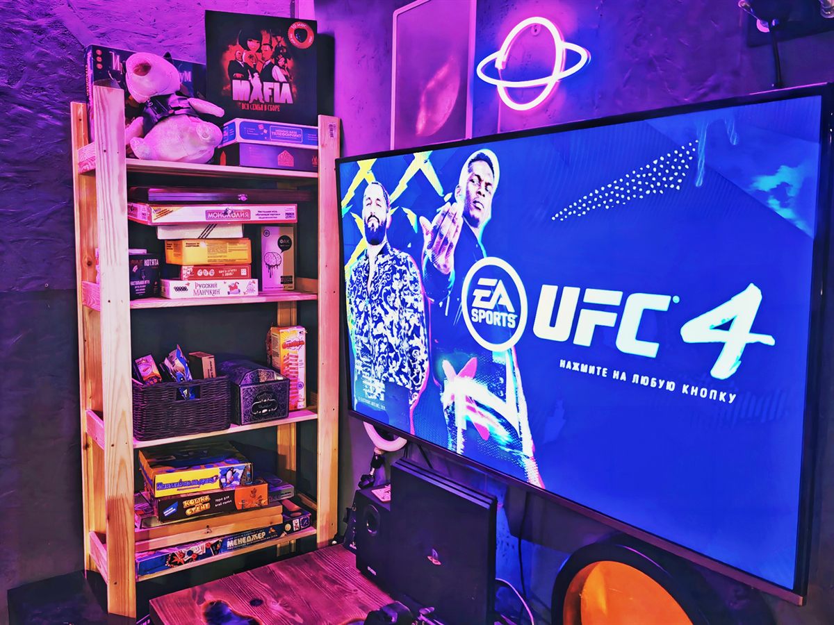Телевизор с PlayStation и полка с настольными играми
